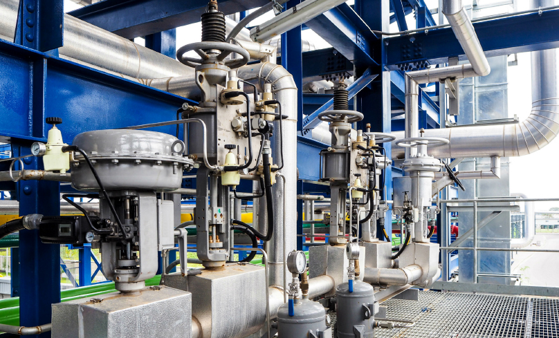 Heavy equipment including control valves on a plant floor.